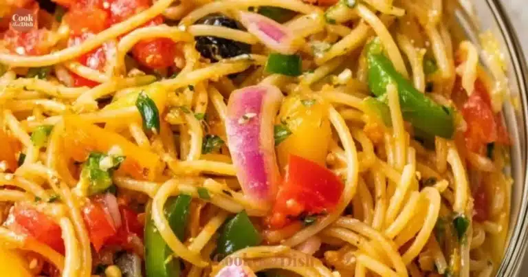 A vibrant bowl of spaghetti salad featuring fresh vegetables and dressing